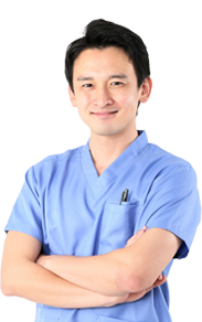 male resident doc wearing scrubs. Smiling with arms folded.